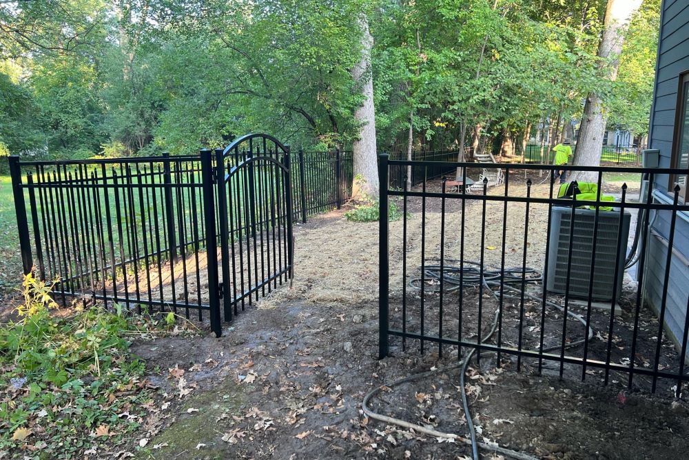Black ornamental aluminum fence installed along a residential yard