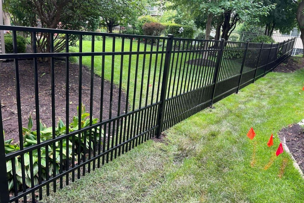Black ornamental aluminum fence installed along a yard