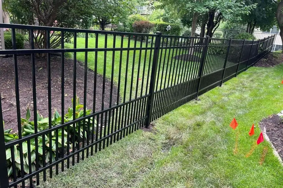 Ornamental aluminum fence running across a graded yard