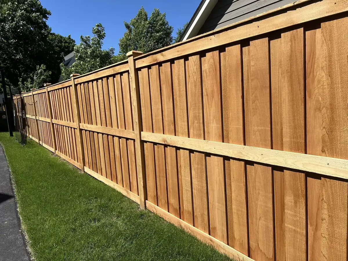 Cedar board on board privacy fence running the length of a side yard beside a house